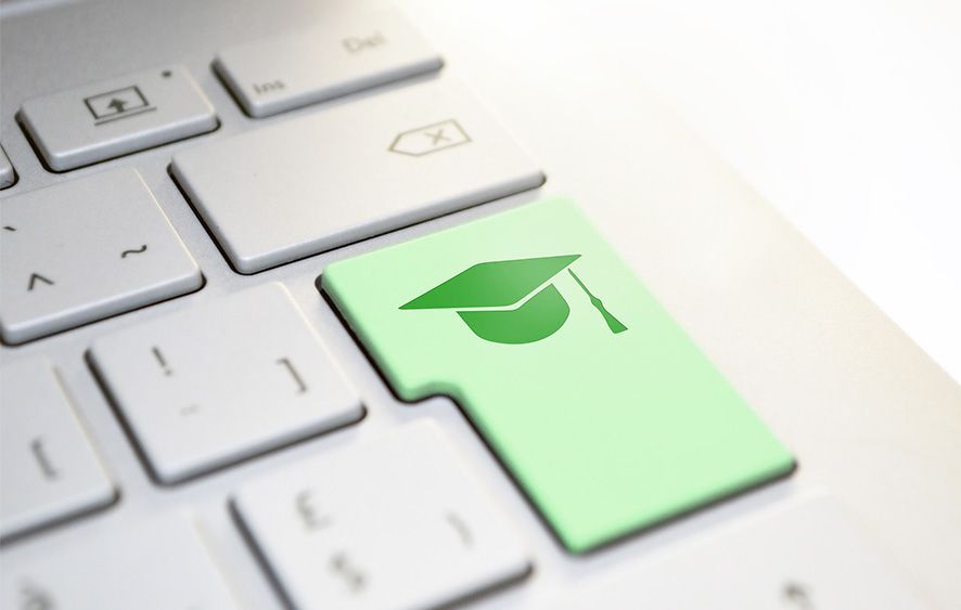 Section of a keyboard with green Enter key and diploma hat