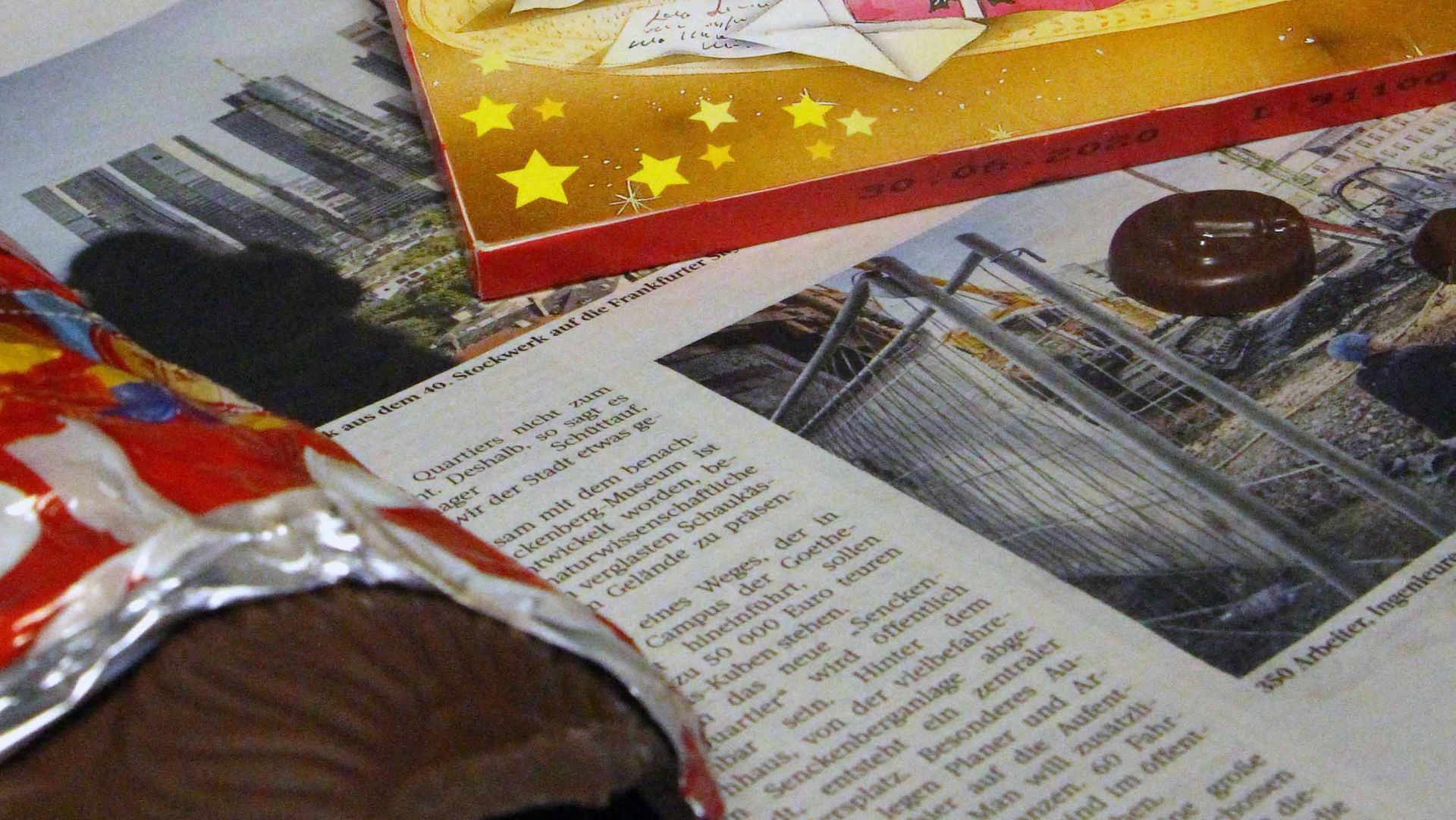 Newspaper, a half unwrapped unwrapped chocolate Father Christmas and an Advent calendar