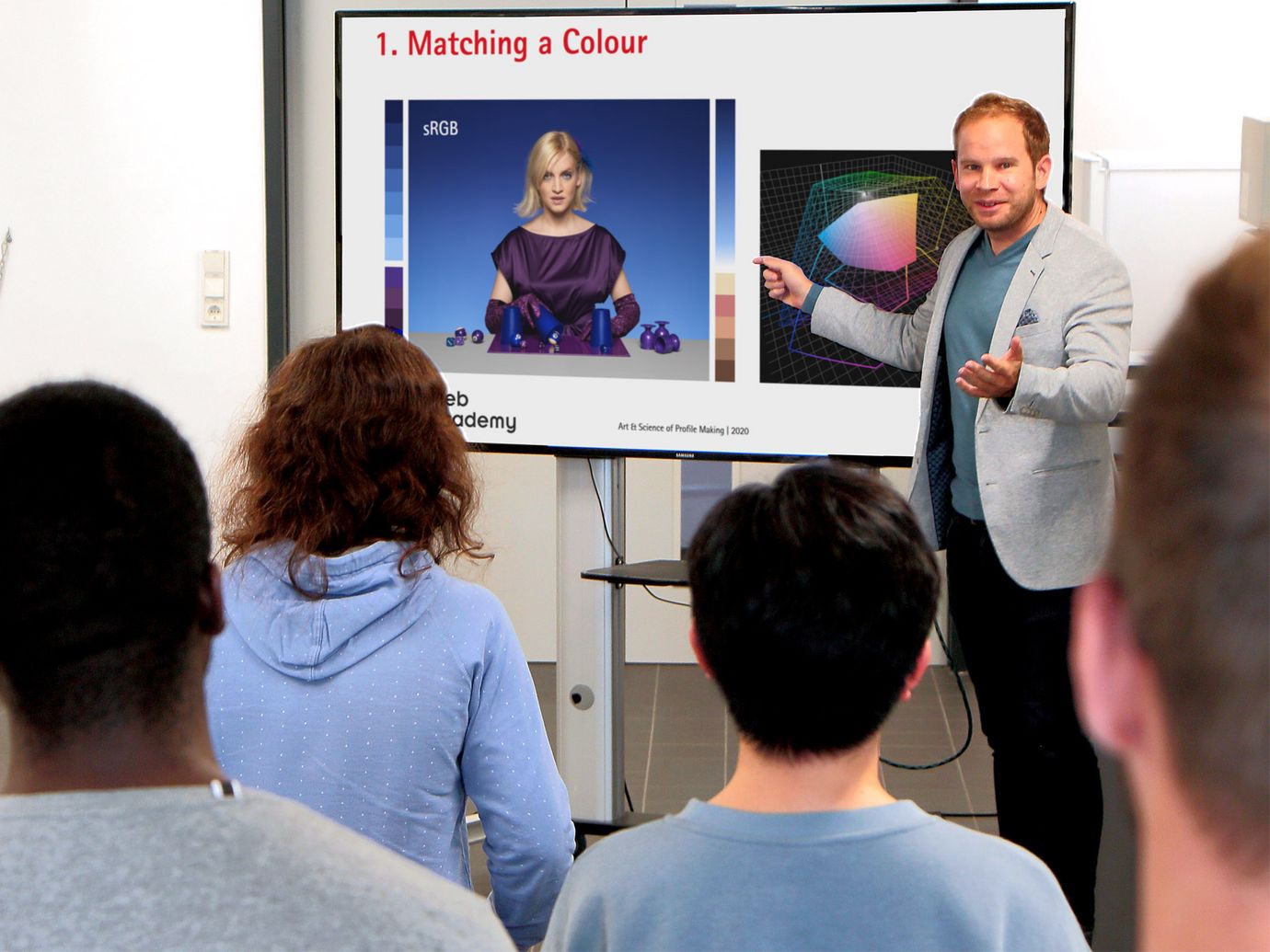 Instructor in front of a screen explaining something to the participants